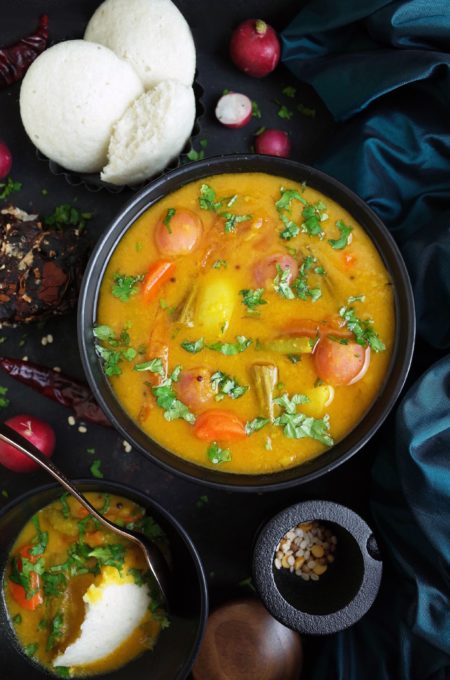 South Indian Vegetable Sambar in a black bowl with Idli