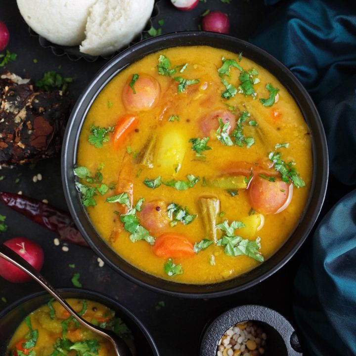 South Indian Vegetable Sambar in a black bowl with Idli