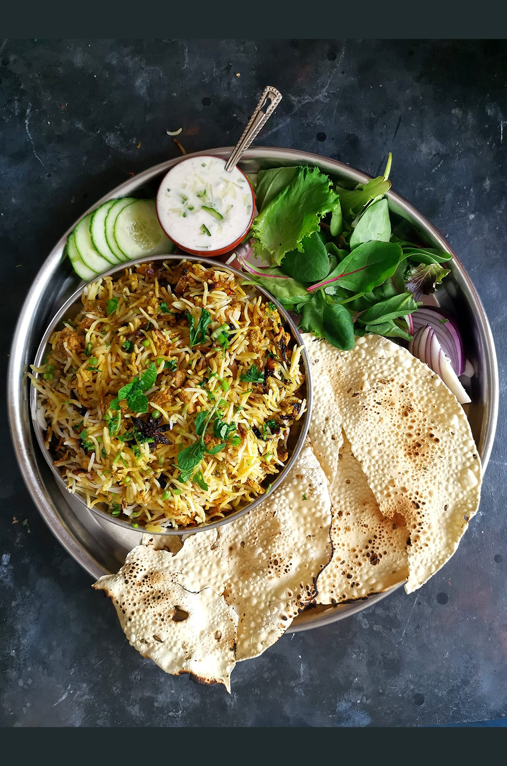 Indian Thali of Jackfruit Biryani, Raita, Salad and Roasted Papad