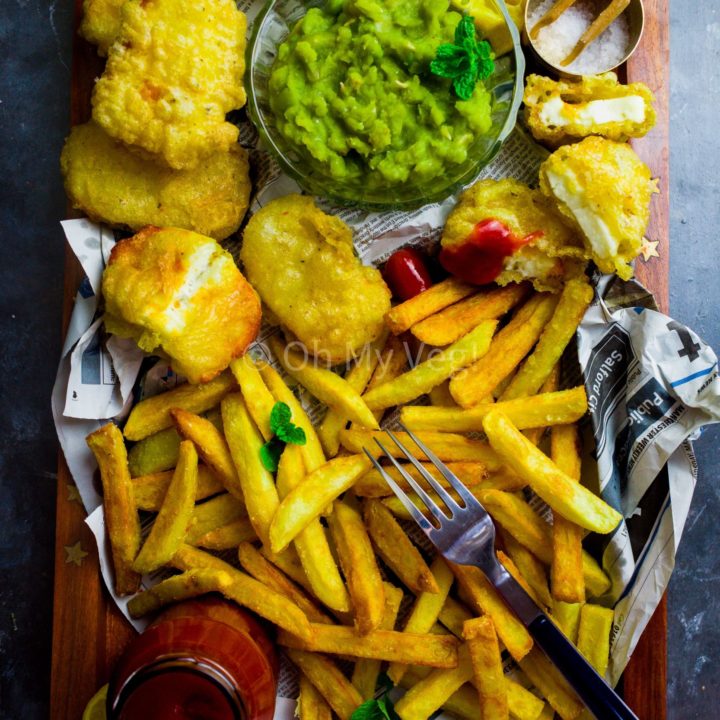 A tray with homemade chips, halloumi fish, mushy peas and ketchup