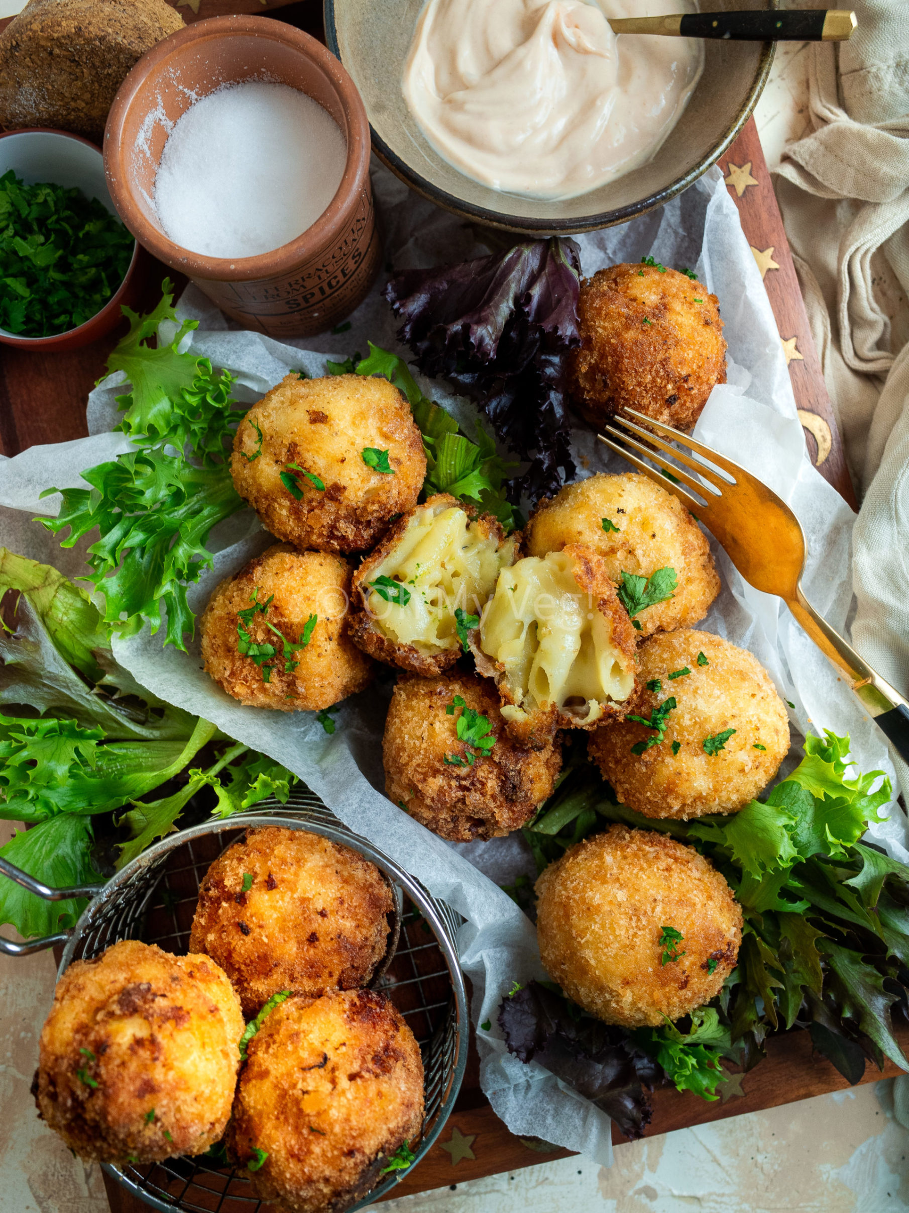 Mac and cheese bites on a plate with mayonnaise and salad