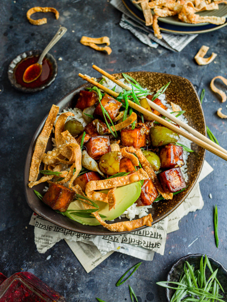 Vegan Indo-Chinese chili paneer in a bowl with rice, avocado, and wonton crisps