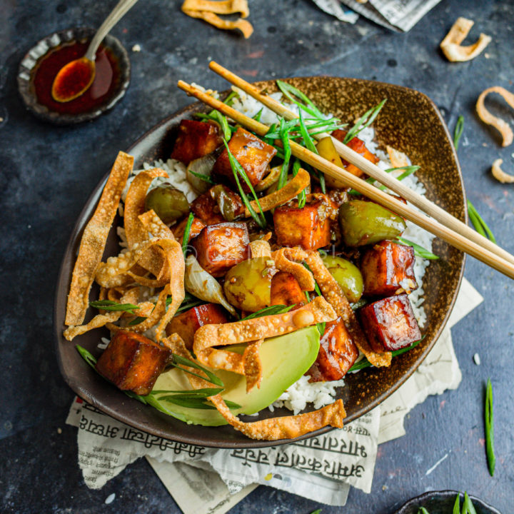 Vegan Indo-Chinese chili paneer in a bowl with rice, avocado, and wonton crisps