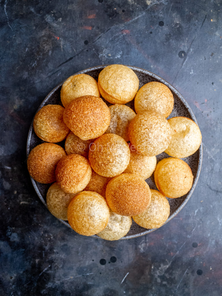 Puri shells on a plate, on a black background. 