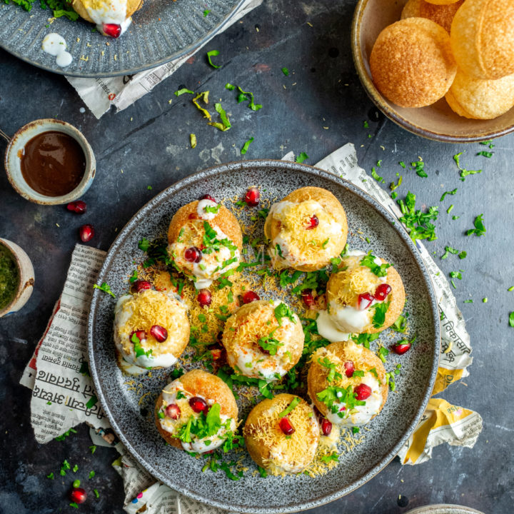 Indian dahi puri on a plate, with tamarind chutney, pomegranate, and readymade puris