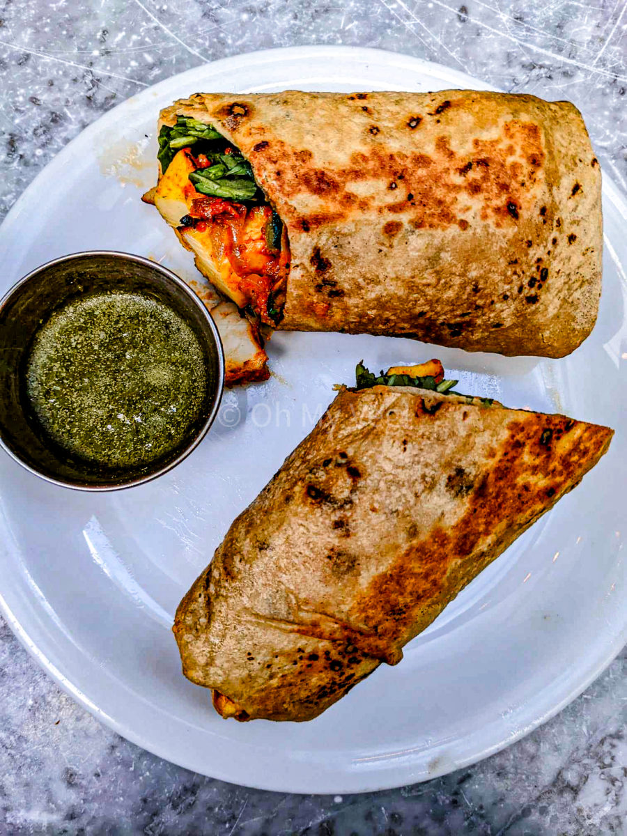 Dishoom Carnaby's paneer roll on a white plate with mint chutney. 