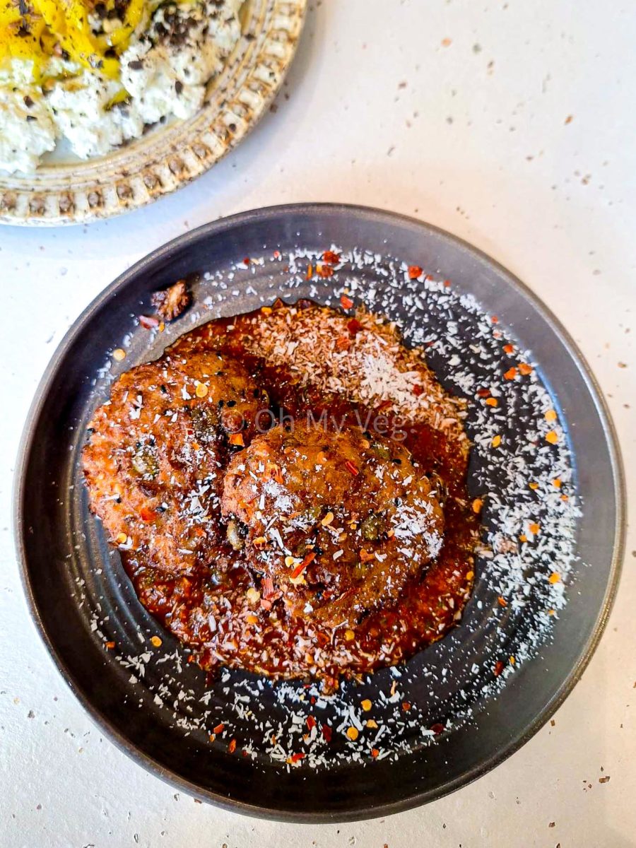 Maray cauliflower bhajis on a black plate.