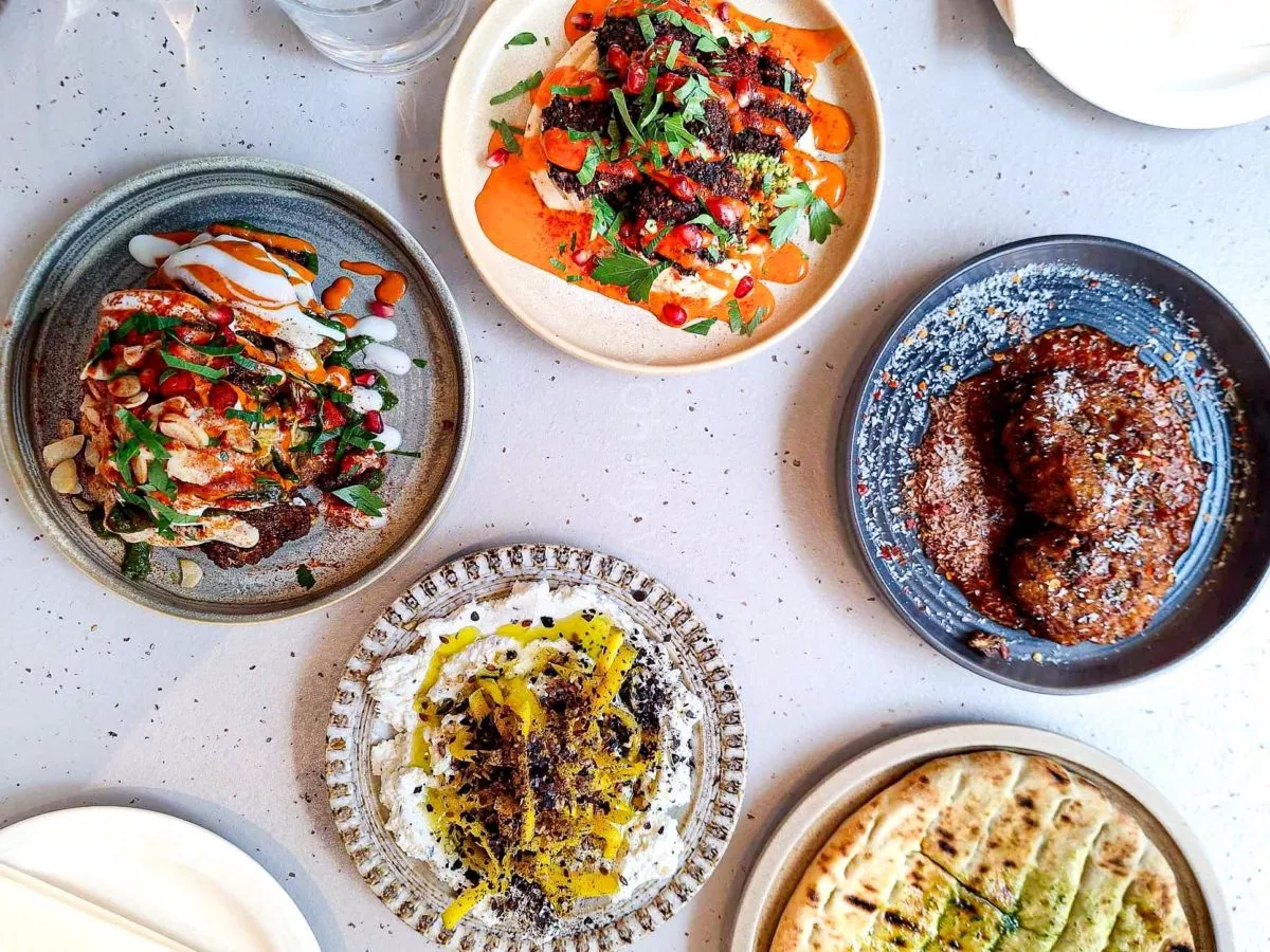 Maray Manchester food flatlay with Maray disco cauliflower, whipped goat's cheese, falafels, cauliflower bhaji, and flatbread. 