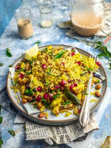 Maharashtrian kanda batata poha on a plate with a teapot in the background