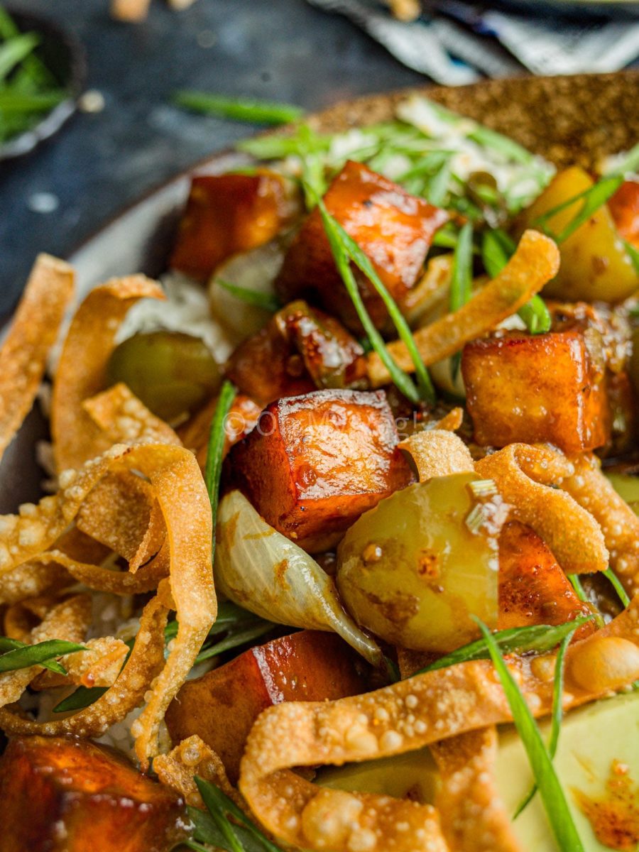 Chili paneer garnished with spring onions and served with wonton crisps.