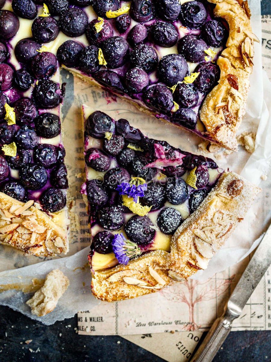 A slice of blueberry cheesecake galette with almonds on the crust. 