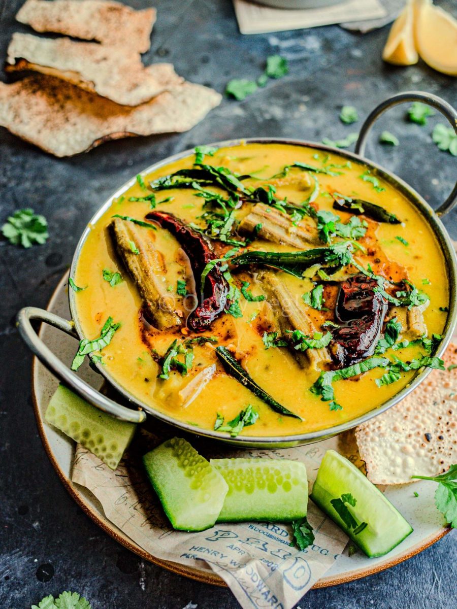 Maharashtrian drumstick dal in a bowl with cucumber and papad.