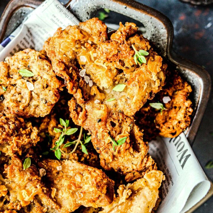 Crispy vegan fried chicken pieces topped with thyme.