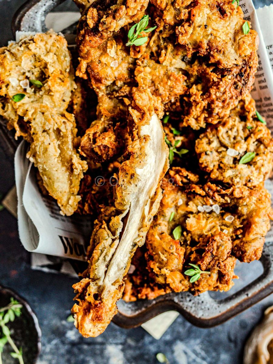 Interior of vegan fried chicken, showing a strip of white oyster mushrooms. 