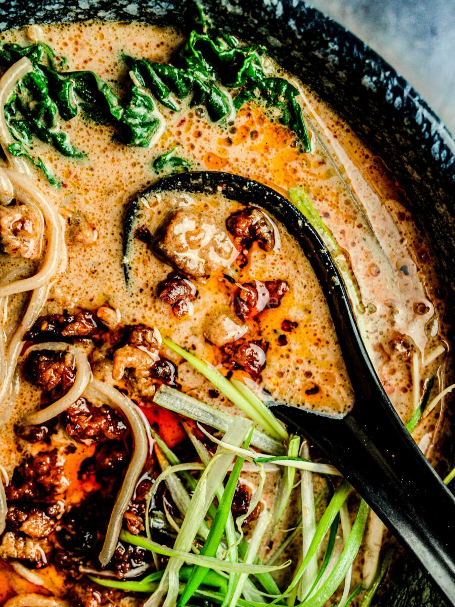 Creamy and rich tantanmen broth with a bowl containing vegan mince. 