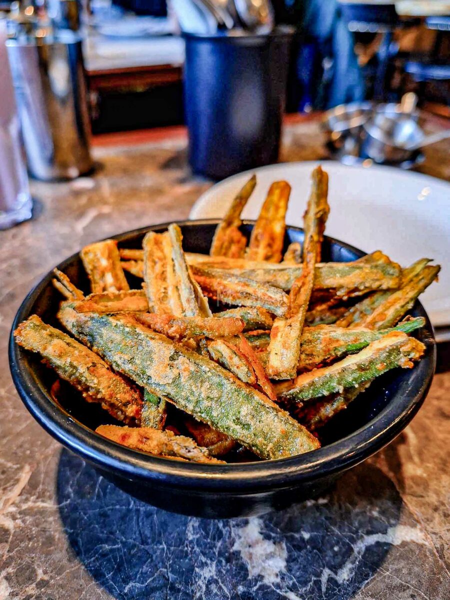 Dishoom okra fries in a black bowl.