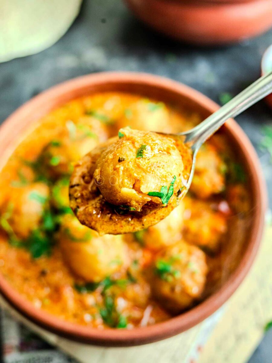 Restaurant-style dum aloo on a spoon. 