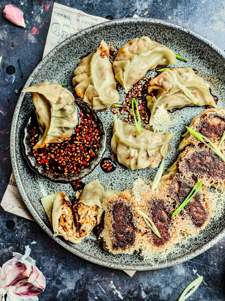 Vegan potstickers with a crispy dumpling skirt on a plate. 