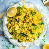 Chitranna or South Indian lemon rice, on a plate with fresh herbs.