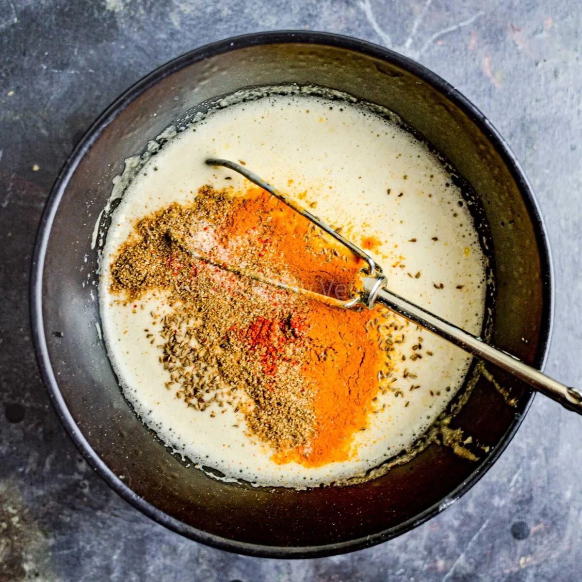 Whisking spices into batter.