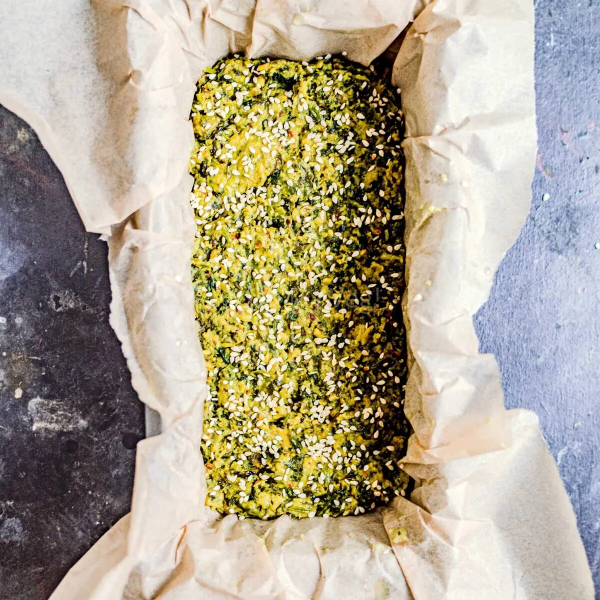 Sesame seeds sprinkled on kothimbir vadi batter.
