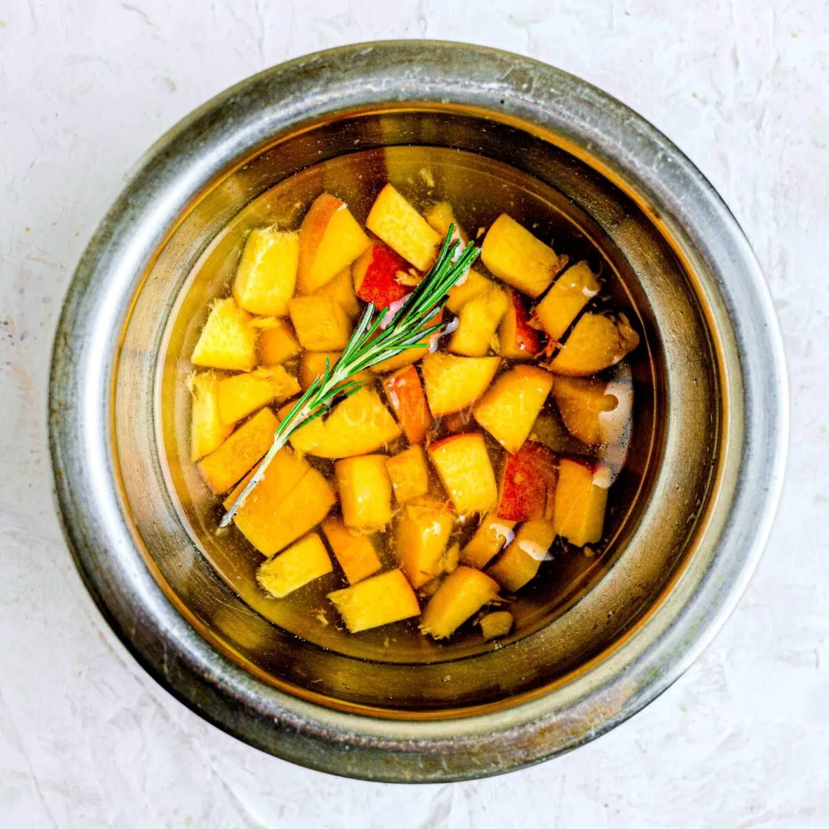Peach, rosemary, and honey in saucepan.