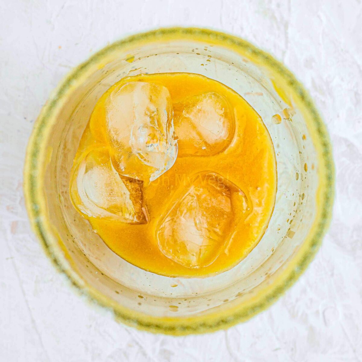 Peach puree and ice cubes in glass.