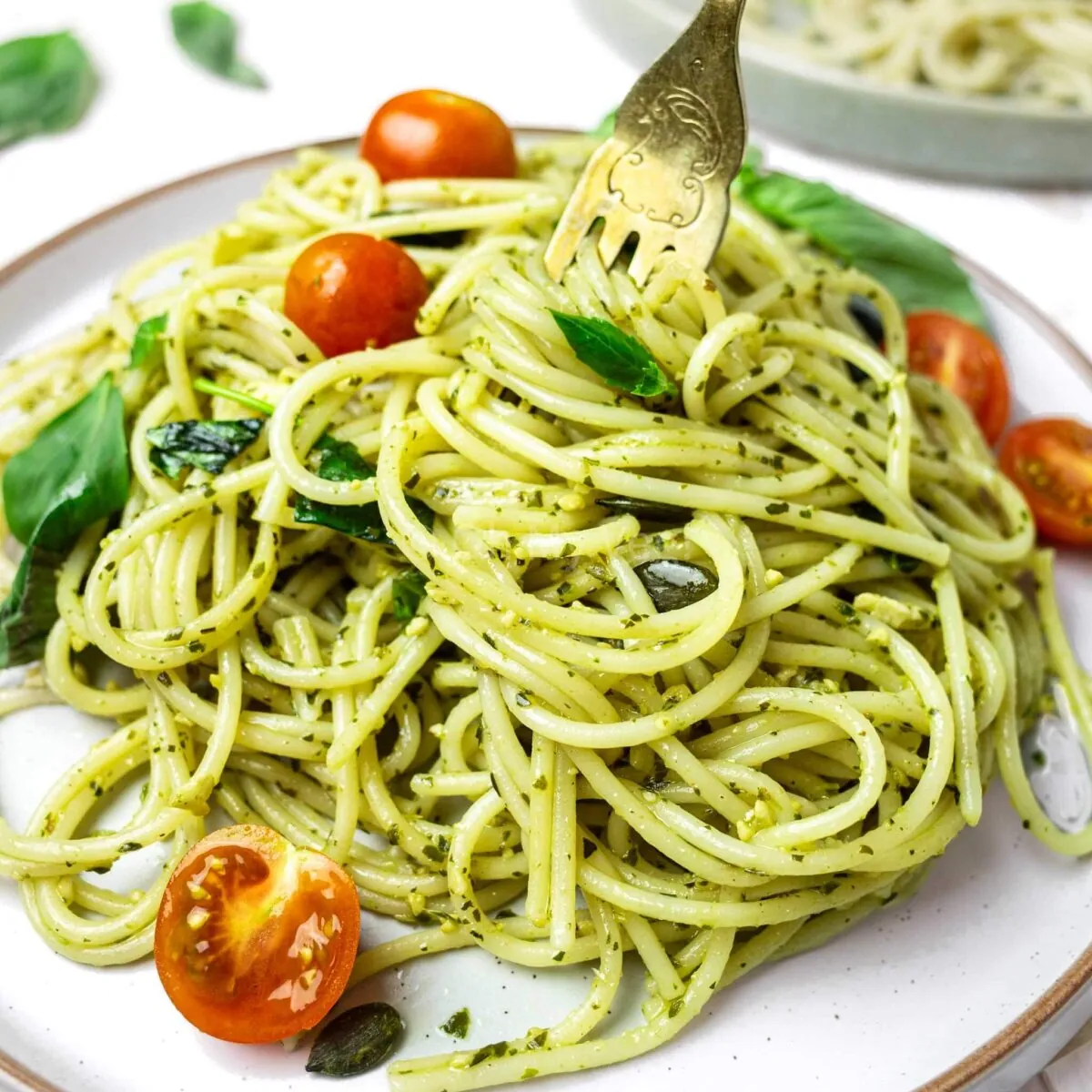 Spaghetti al pesto with a fork twisting the pasta.