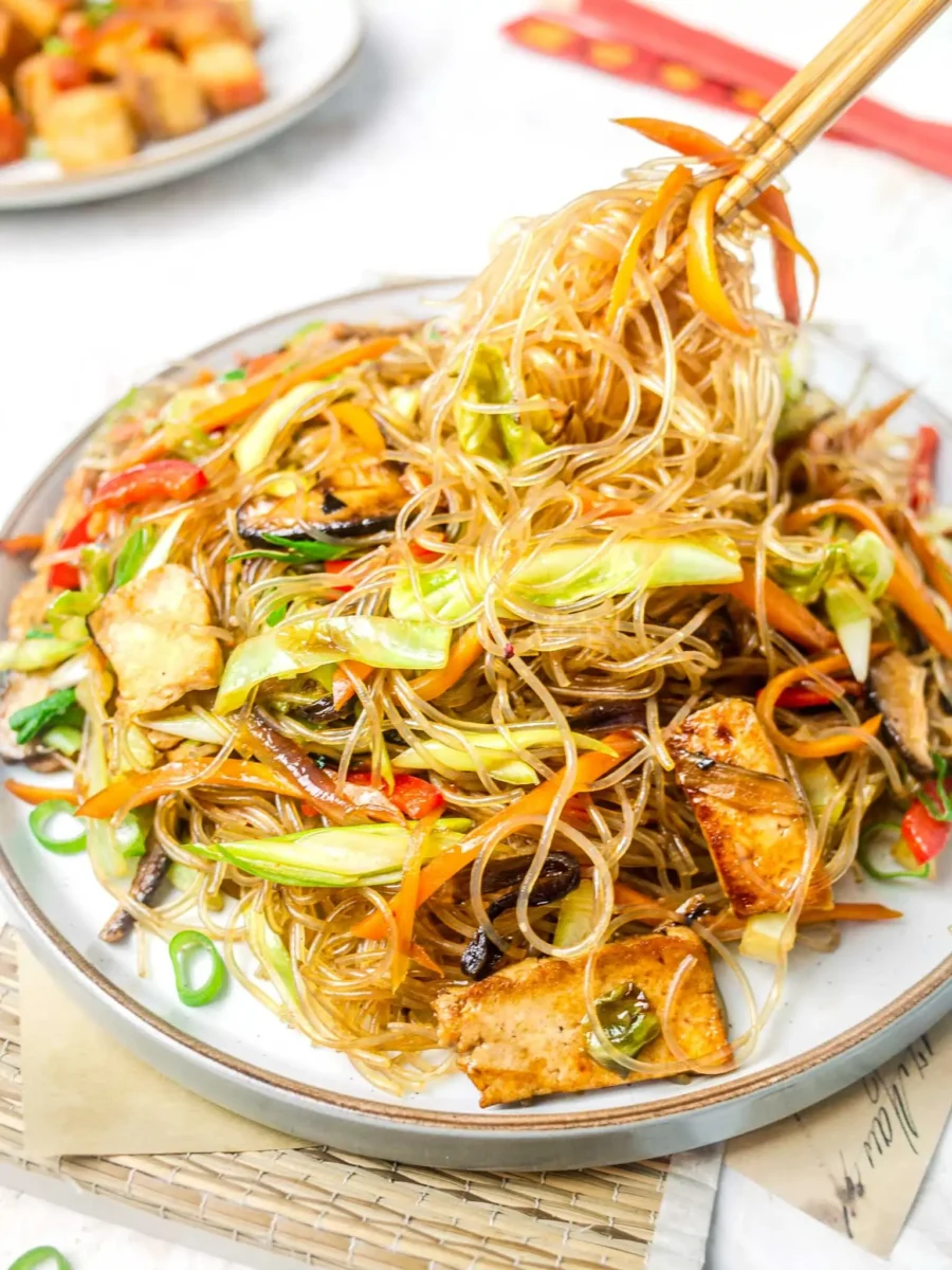 Chopsticks lifting glass noodle stir fry.