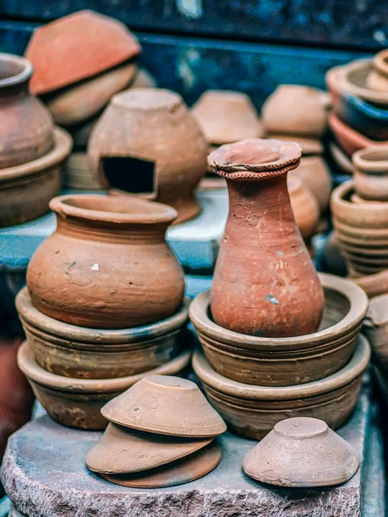 Rustic clay Indian cookware in a pile.