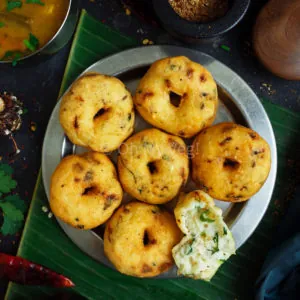 Medu Vada on a steel plate with banana leaf in the background