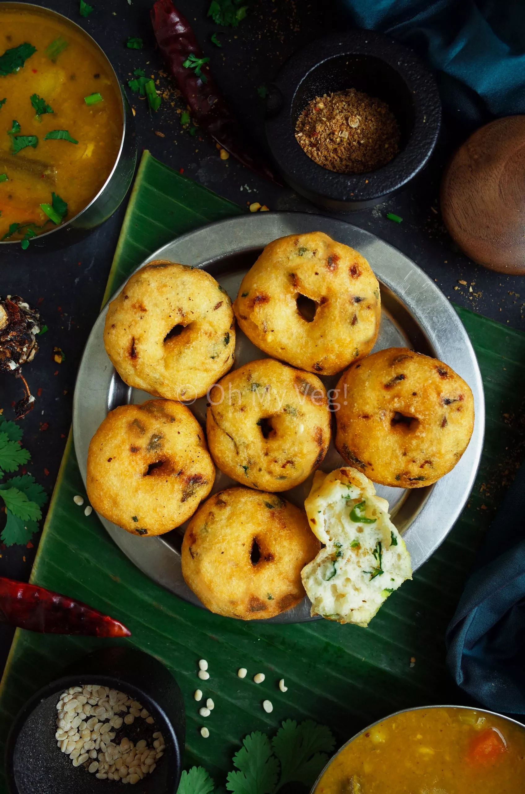 Medu Vada on a steel plate with banana leaf in the background