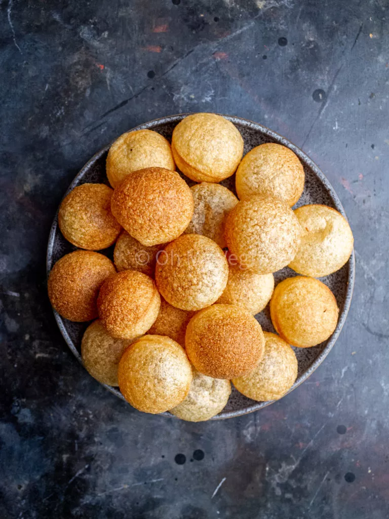 Puri shells on a plate, on a black background.