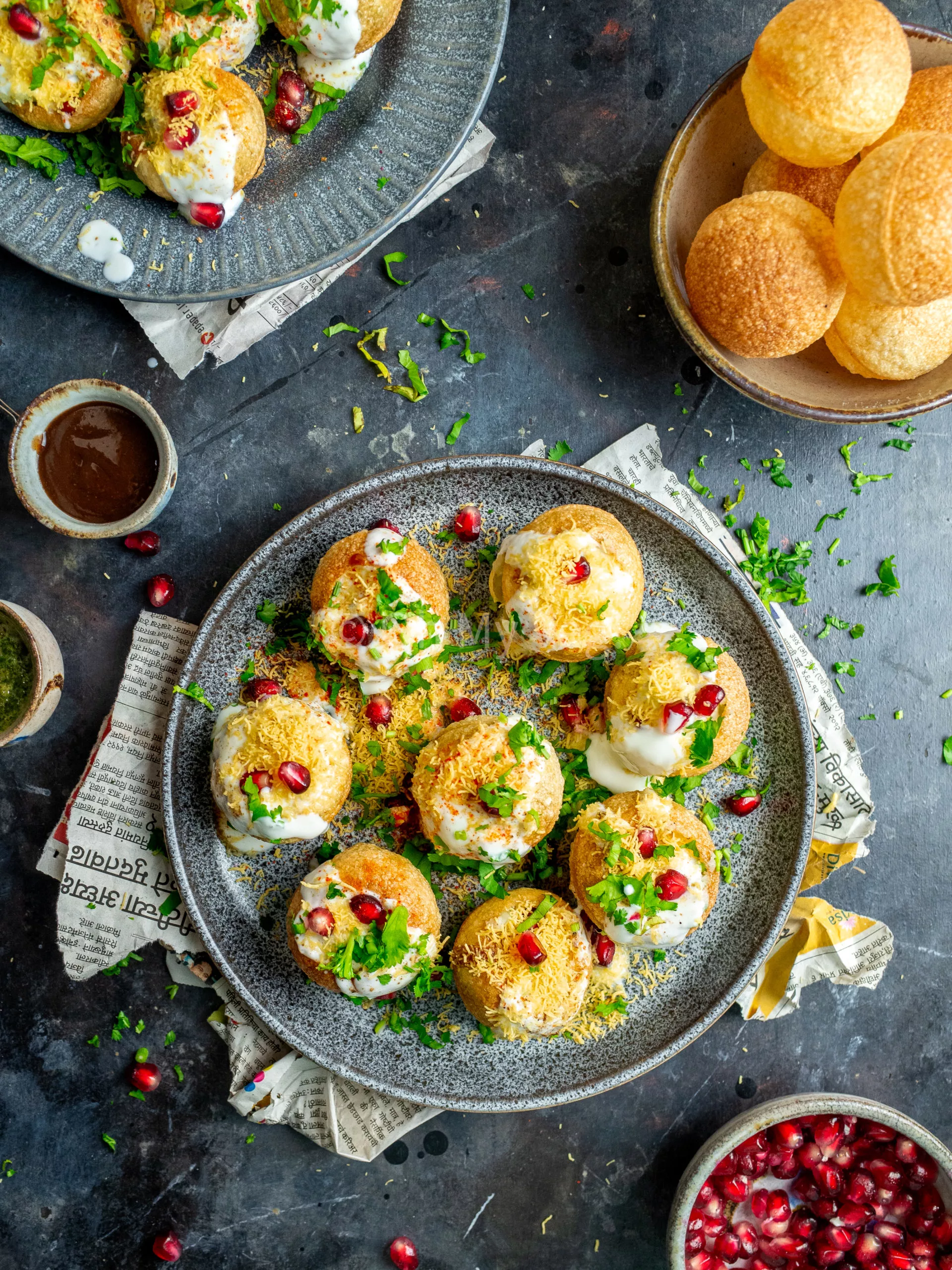 Indian dahi puri on a plate, with tamarind chutney, pomegranate, and readymade puris