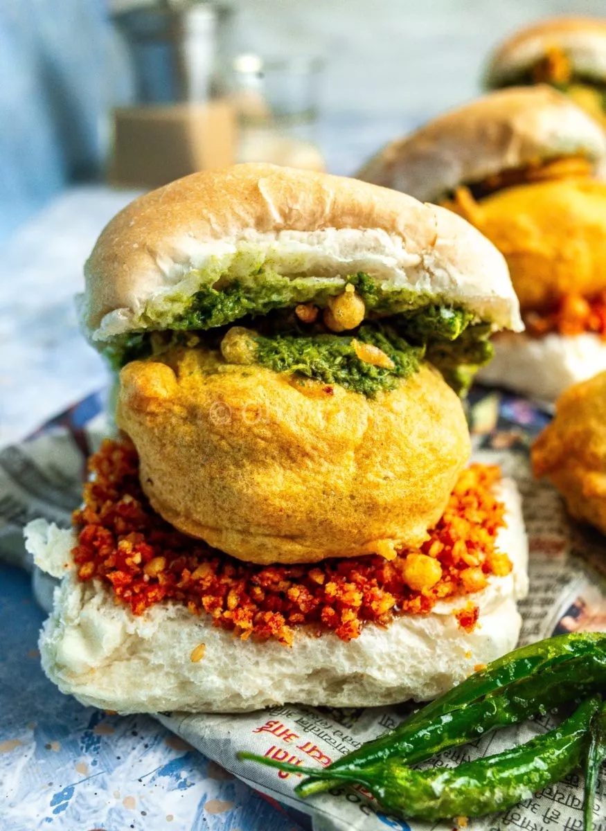 Mumbai style vada pav burger with green chutney, batata vada, and dry garlic chutney.