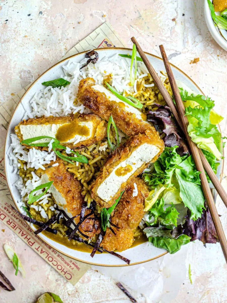 Tofu katsu curry with salad on a plate.
