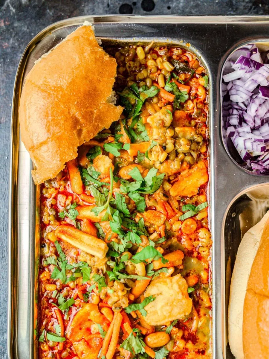 Misal pav on a plate with a torn-off piece of bread.