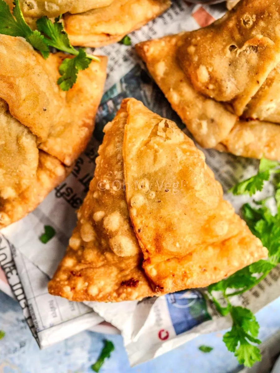 Punjabi samosa on newspaper.