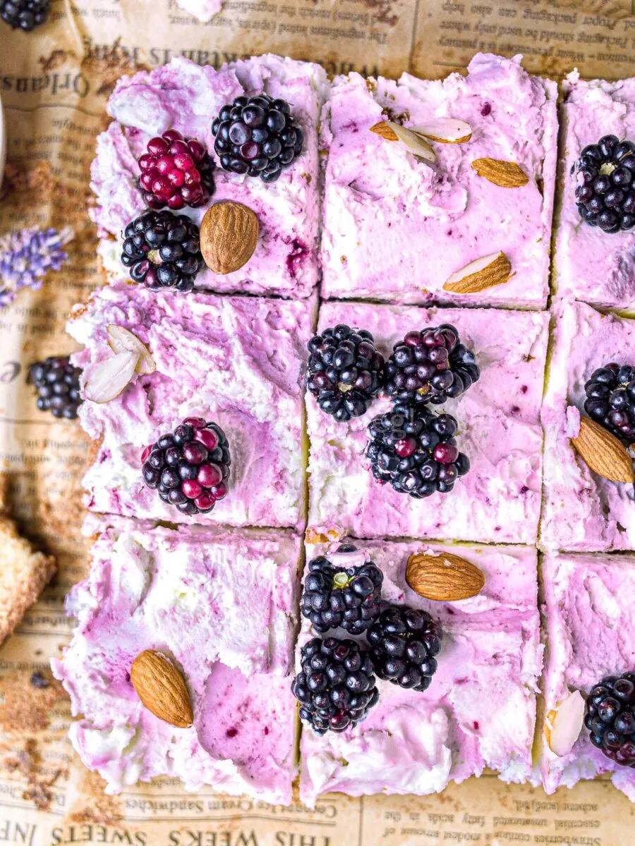 Blackberry almond cake cut into nine squares.