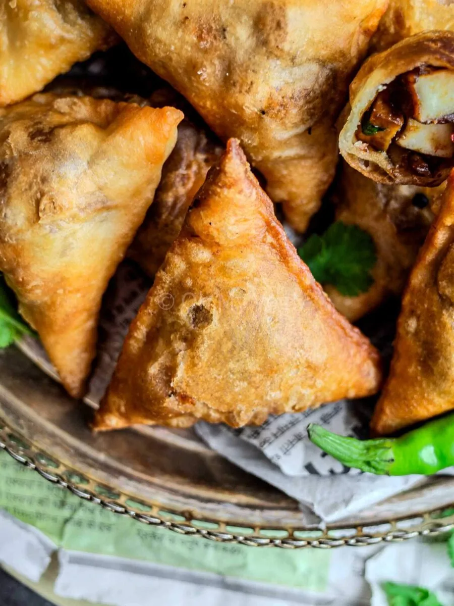 Chilli paneer samosas on a silver platter.