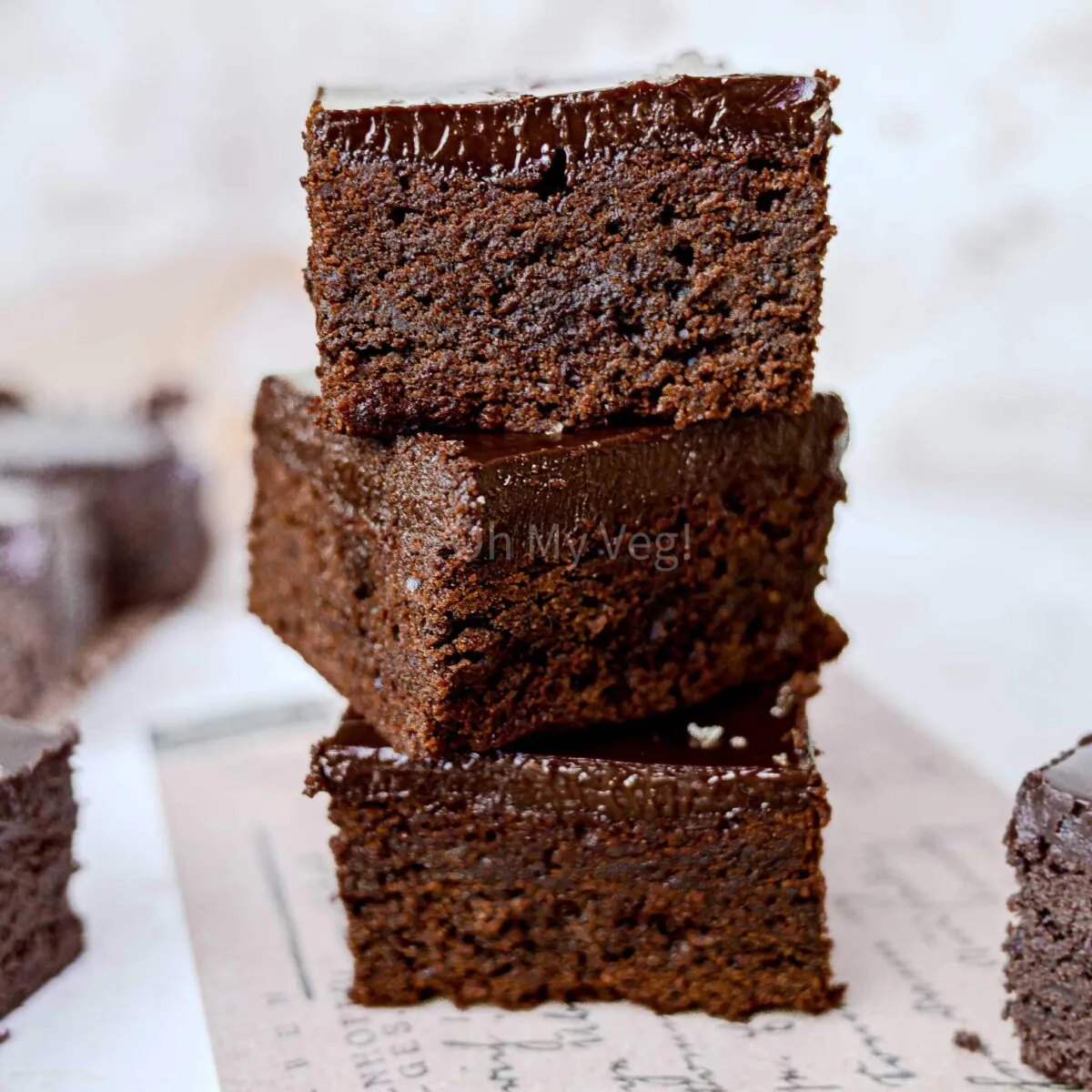 Three chocolate ganache brownies in a stack. 