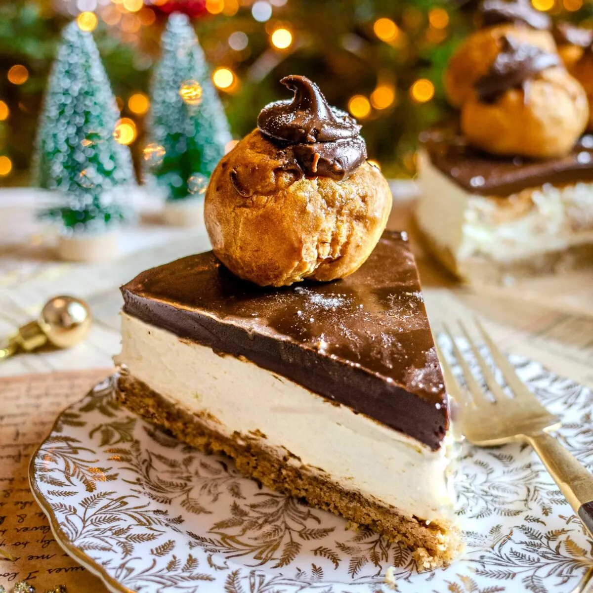 Profiterole cheesecake slice on a gold and white plate.