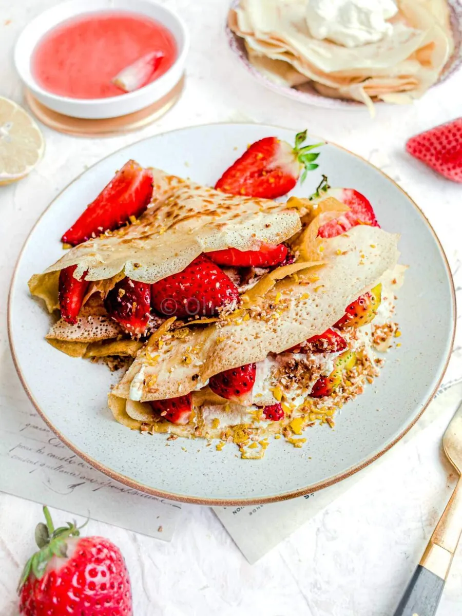 Coconut milk crepes with strawberries, on a white plate.