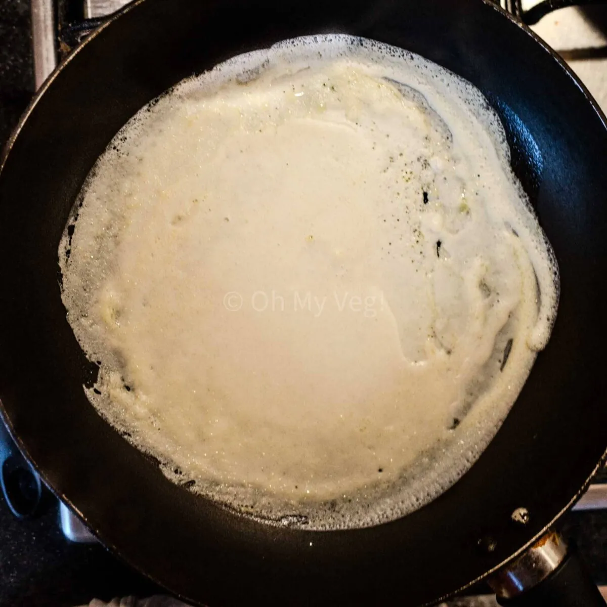 Coconut milk crepe cooking in a pan.