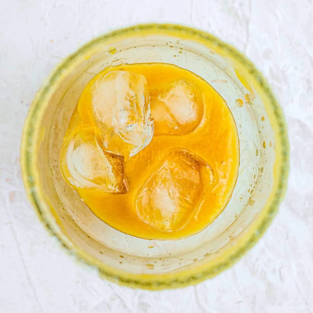 Peach puree and ice cubes in glass.