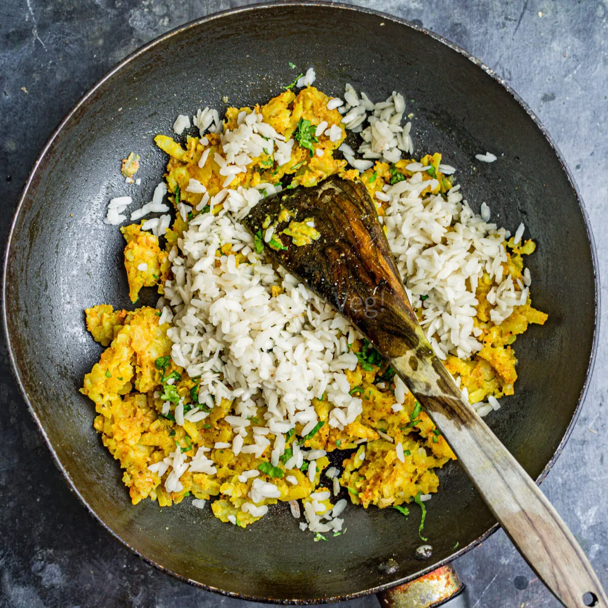 Poha added to the frying pan.