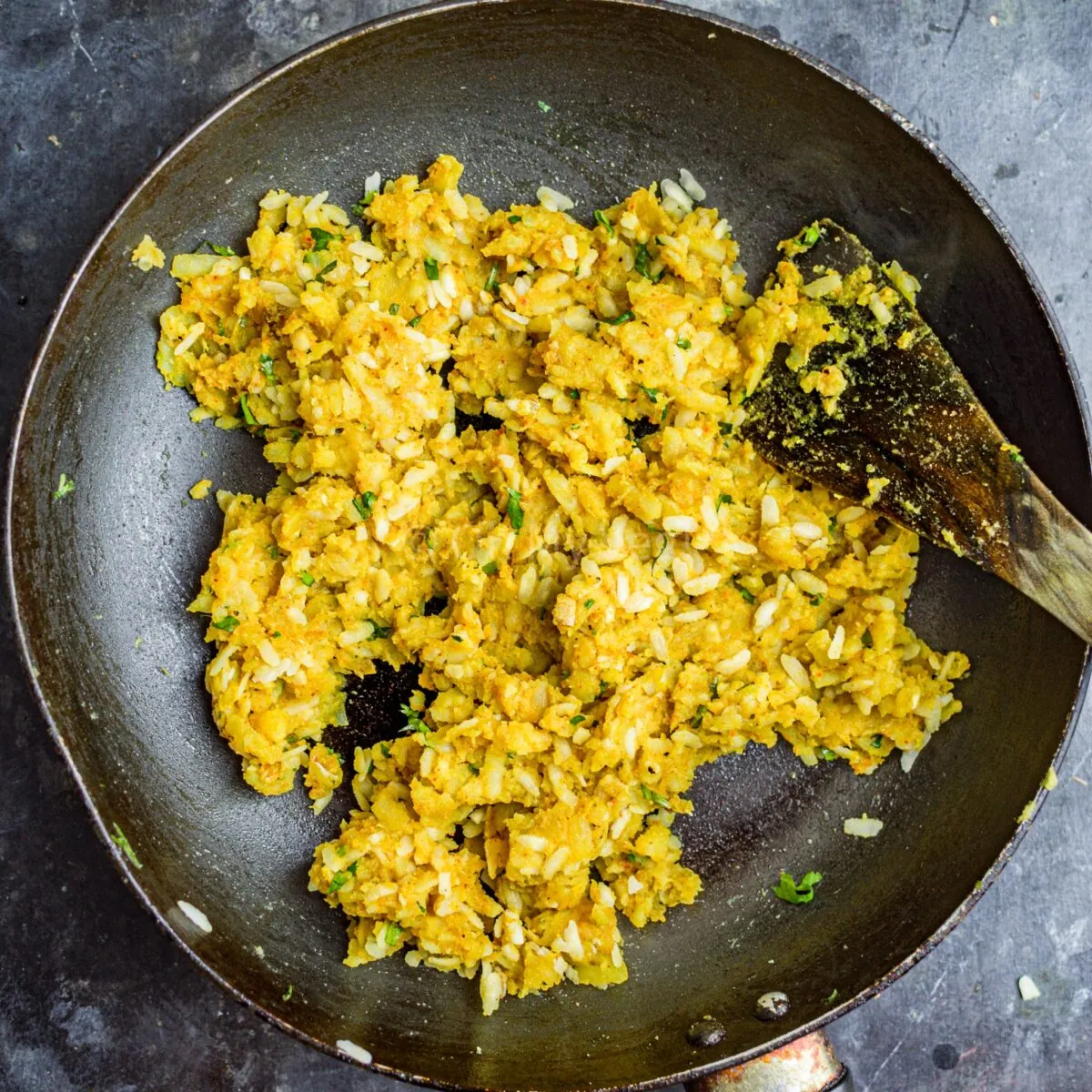 Spiced potatoes mixed in a pan.