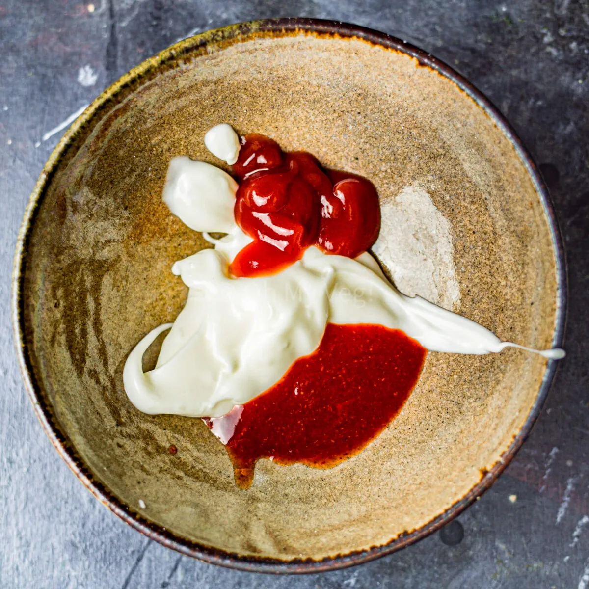 Mayonnaise, ketchup, and chilli sauce in a bowl.
