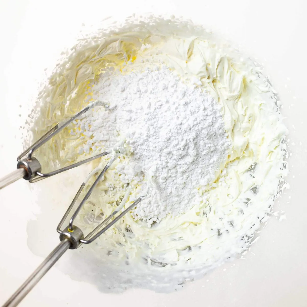 Double cream and icing sugar in a bowl.