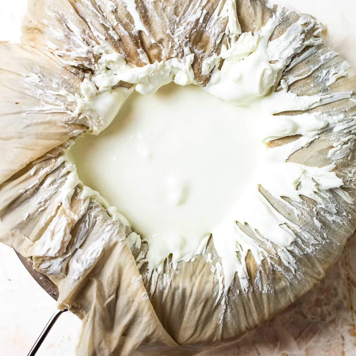 Thick strained yoghurt in a cheesecloth.